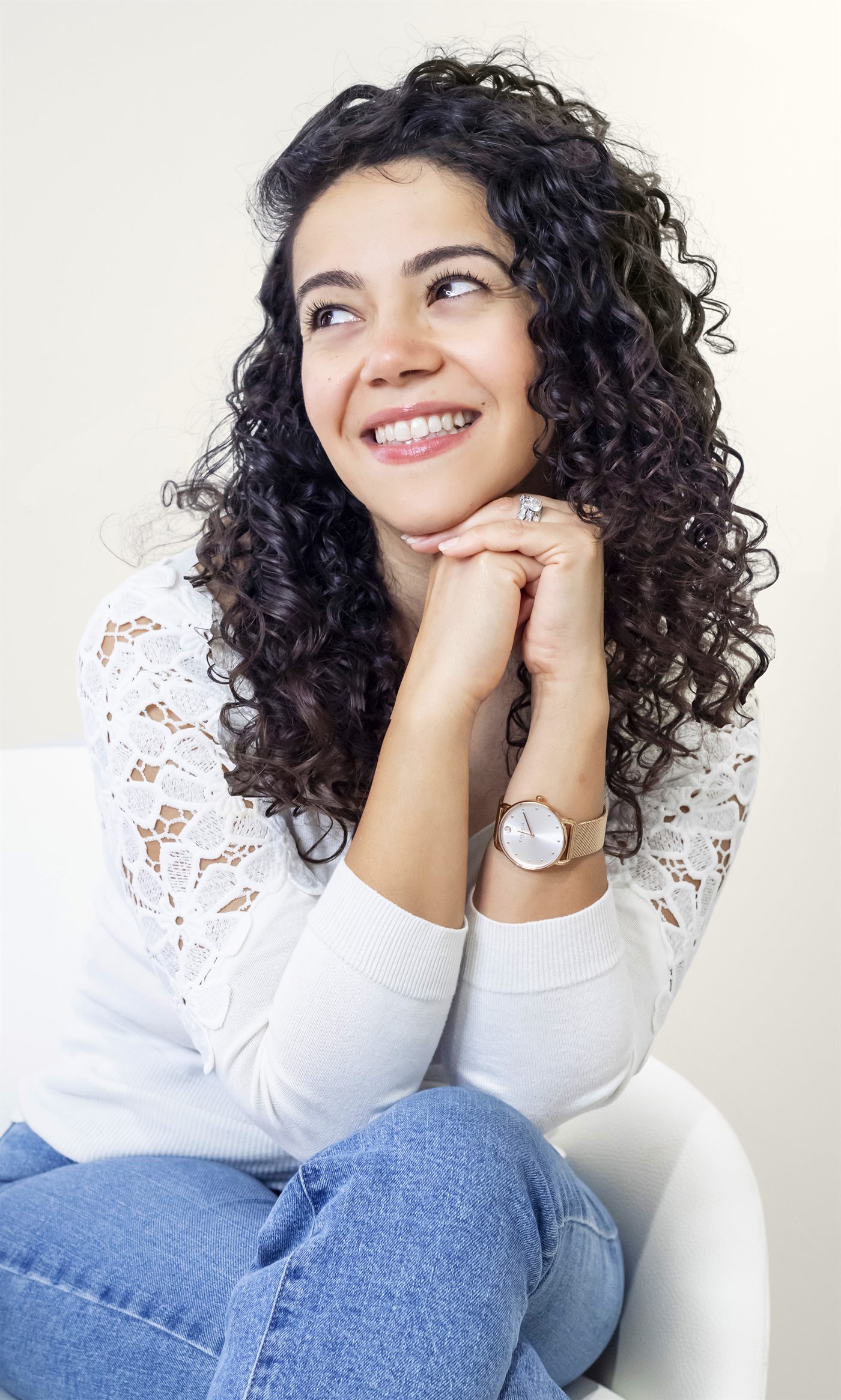 Jocelyn Mina, smiling, seated with her chin resting on her hands
